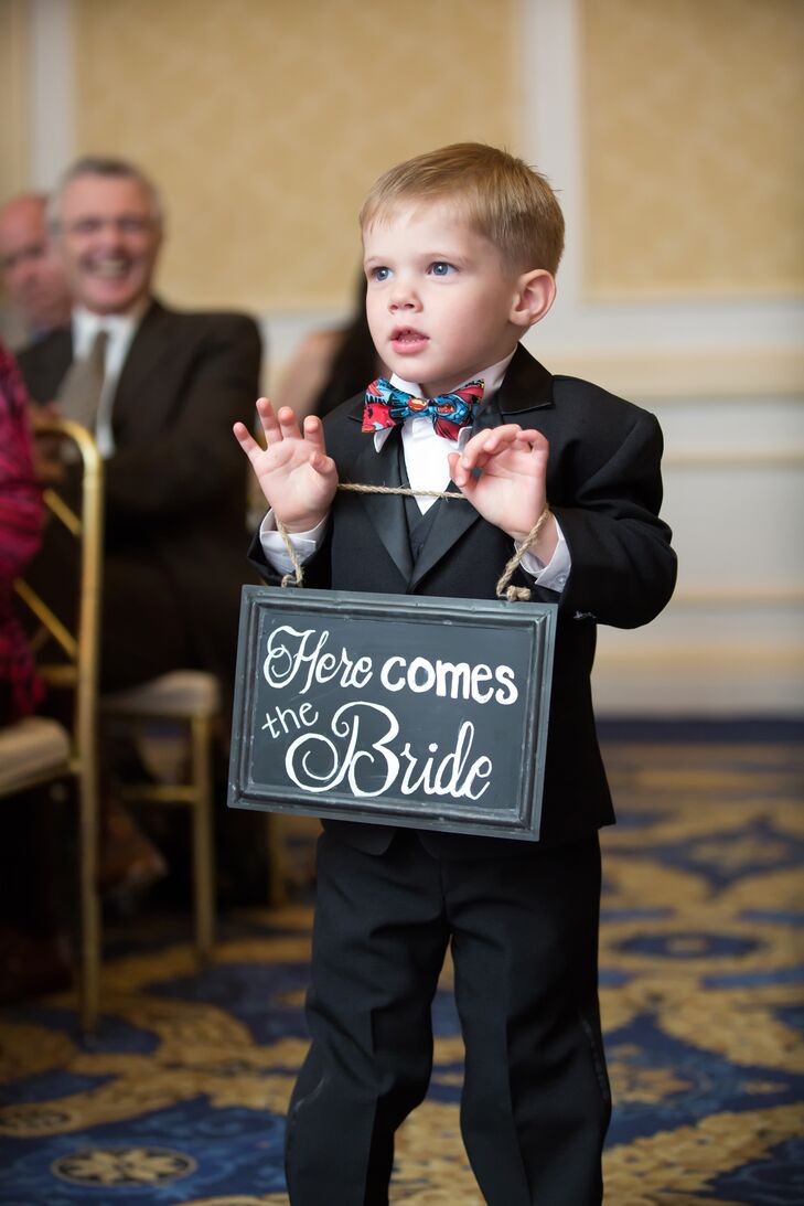 A child attendant carried a small sign down the aisle that said "Here Comes the Bride."