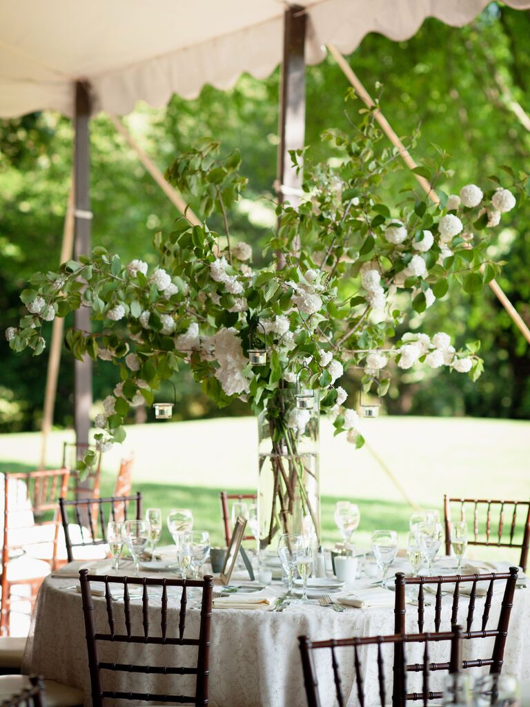tall wedding centerpiece with greenery branches and foraged white flowers