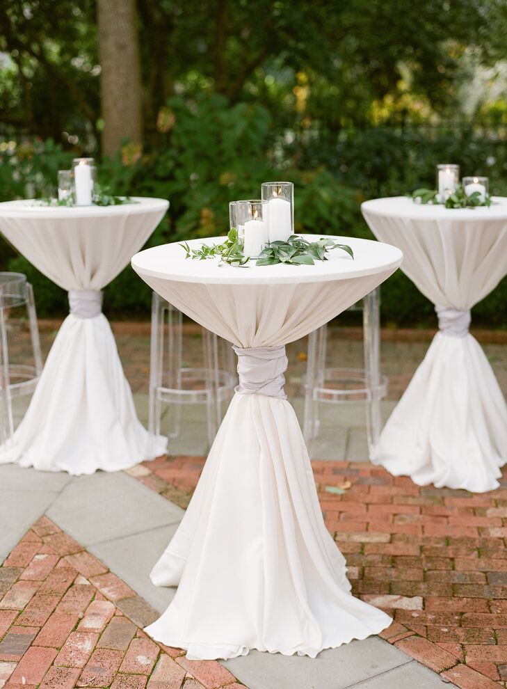 White Pillar Candles and Greenery Atop Cocktail Tables
