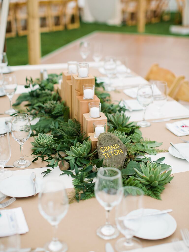 wedding centerpiece with wooden votive candle holder surrounded by succulents