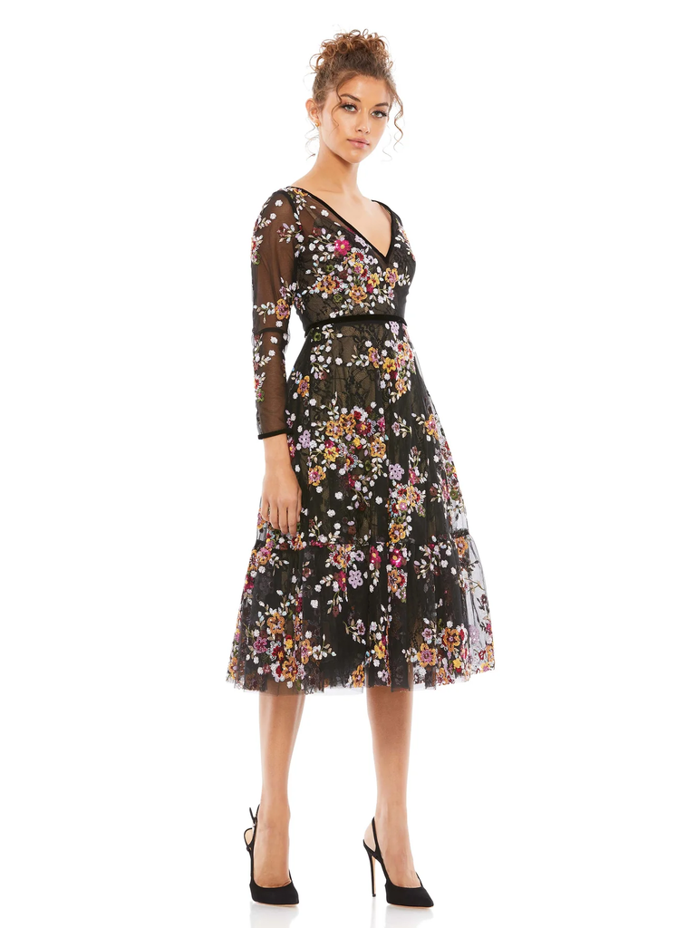 A model shows off this knee-length mother of the bride dress with floral overlay.