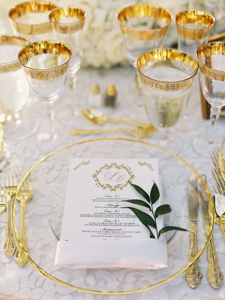 Elegant gold rimmed glassware and dinnerware at regencycore wedding reception