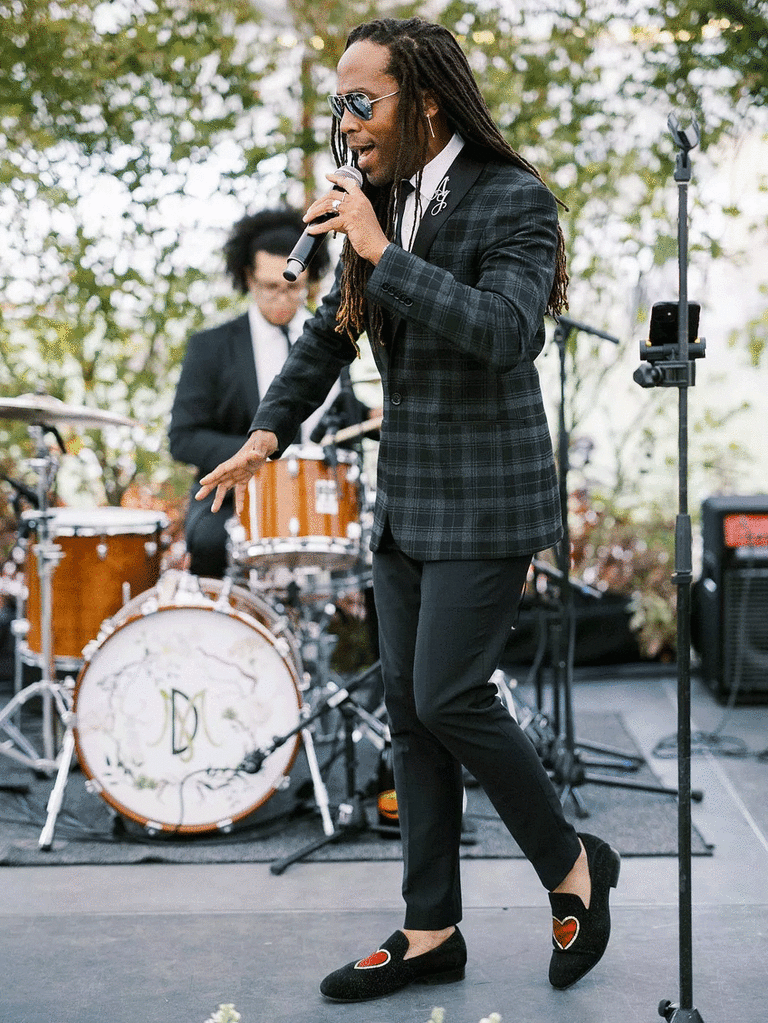 Band singer performing top 100 love songs outdoors during wedding reception.