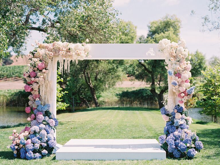 pastel wedding ceremony arch with blue, pink and white hydrangeas, pink roses and white amaranthus against a white square frame