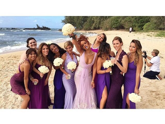 Rihanna and other bridesmaids pose with their bouquets on the beach. 