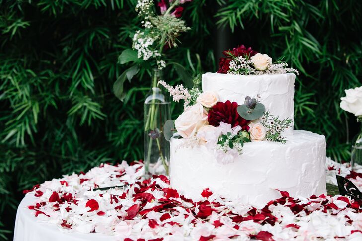 The simple yet elegant two-tier cake featured rustic ivory frosting and live floral accents.