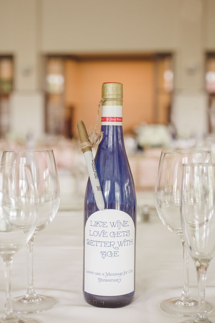 Instead of table numbers, each table had a bottle of wine and a gold pen for guests to leave messages. The couple plan to drink the corresponding wine bottle for each anniversary.