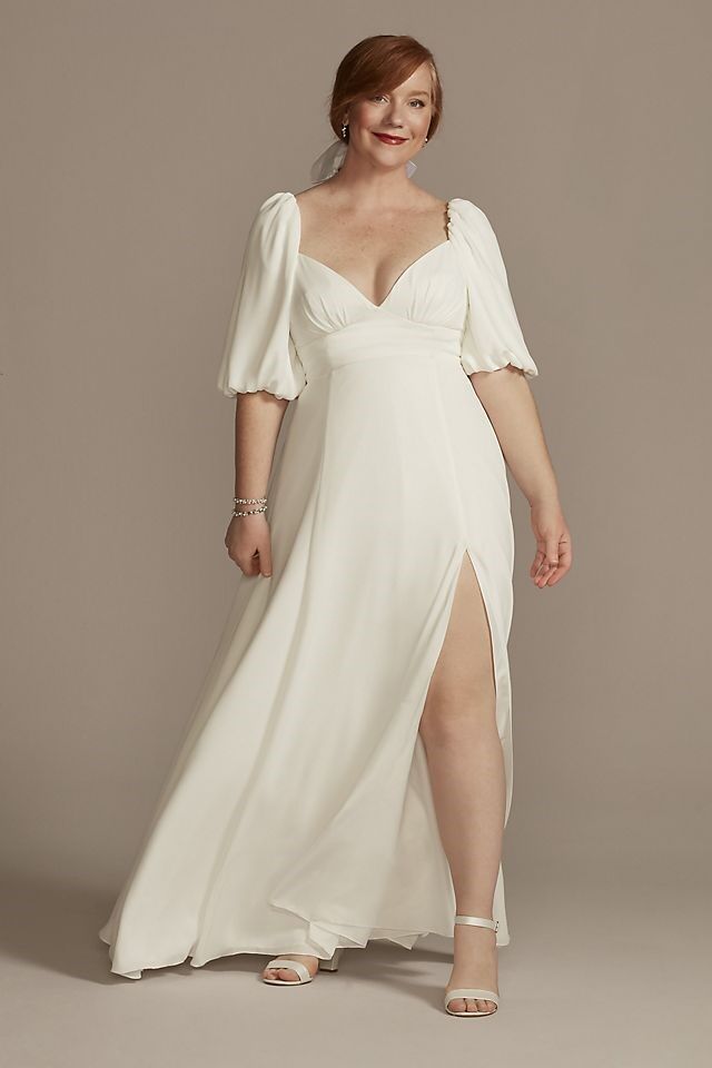 Model wears a white dress with a sweetheart neckline and puffed sleeves. 