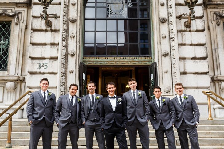 Ryan wore a black tuxedo designed by Indochino with a black bow tie to match. His groomsmen stood beside him, wearing gray tuxedos with matching ties from Black by Vera Wang.