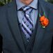 The groom and groomsmen wore three-piece gray suits with gray and purple patterned ties. They completed the look with orange rose bloom boutonnieres.