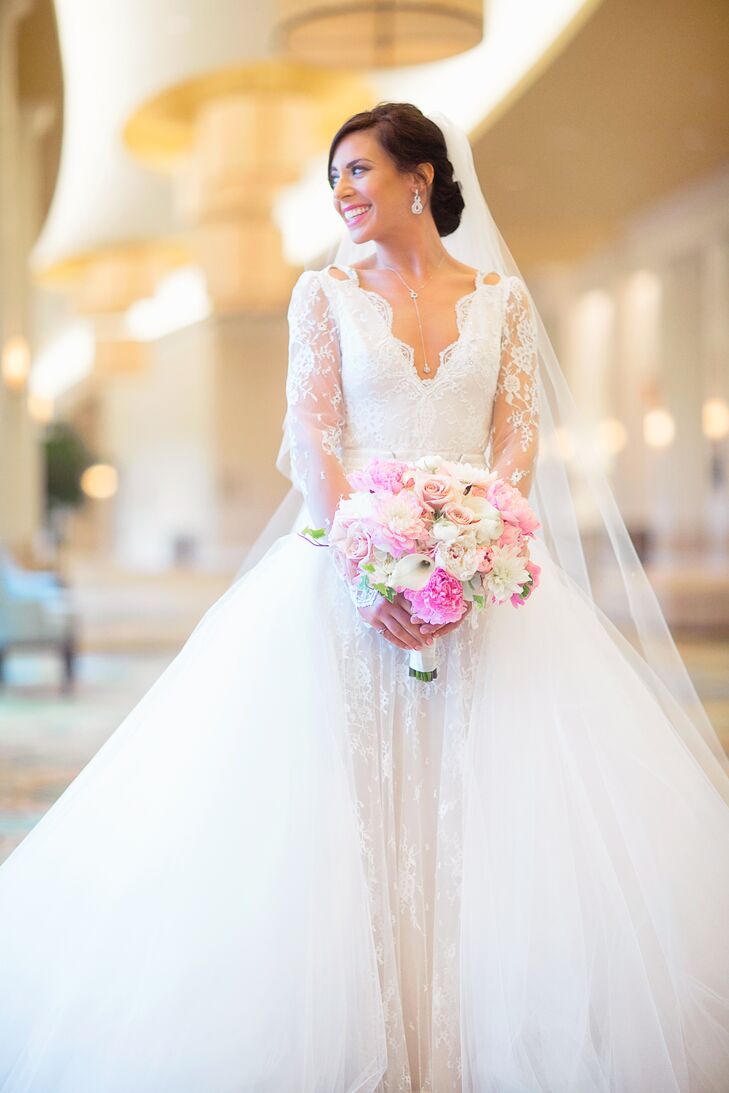 For a little twist during the ceremony (and to feel like a princess!), Shayna added a detachable, full-length Monique Lhuiller tulle and lace skirt to her Inbal Dror fitted gown. “There was so much detail from the pearl buttons, the scalloped lace finish on the sleeves, the blush lining underneath the ivory lace,” the bride says. “It was magical.” She added a little sparkle with a cathedral-length tulle veil adorned with Swarovski crystals