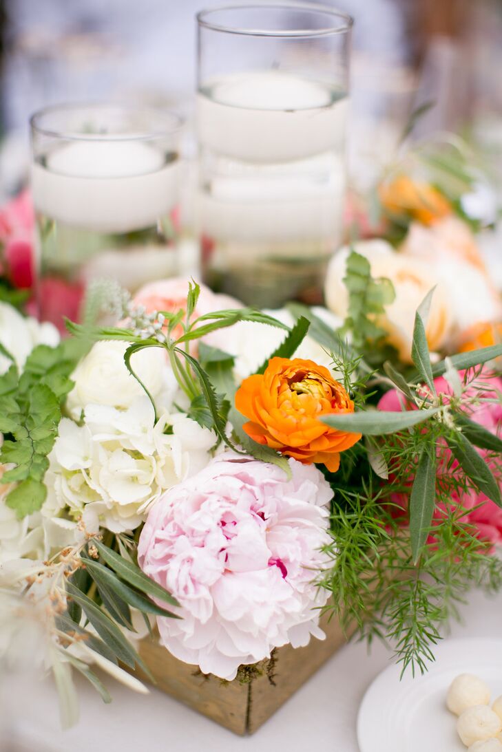 As the day progressed from ceremony to reception, color was added to the decor through bright florals. Orange, pink and white were used in the centerpieces, which featured a small wooden box and floating votive candles.