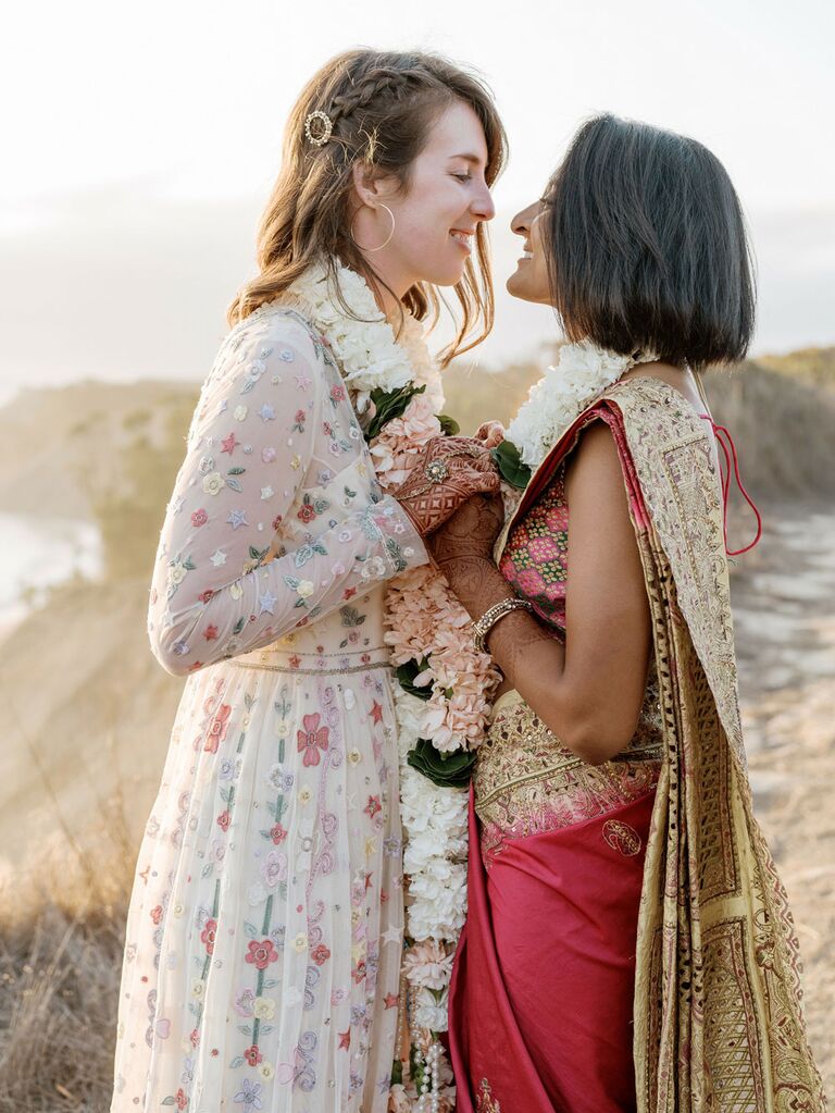 Bohemian brides wearing colorful floral wedding dress and traditional Indian red dress
