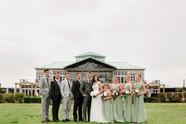 Keeping with a soft, earth-tone-inspired color scheme, the wedding party stood out in shades of pale green and gray. Every person sported a different look. Each bridesmaid and junior bridesmaid picked out a timeless, floor-length chiffon dress with ruching along the neckline from Bella Bridesmaids. For the groomsmen, they all followed Charlie’s lead and sported gray suits with a purple or blue ties. The bridesmaids reflected their looks with purple and white flowers throughout their bouquets.