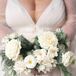 A winter-themed bridal bouquet for a Christmas wedding with white flowers and pine and cedar greenery.