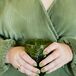 Guest in Green Holds Green Wine Goblet at Wedding Reception