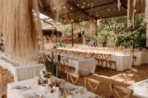 Long Reception Tables With White Linens On Sand, Under Edison Bulbs and Grass Chandeliers