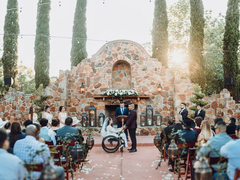 wedding officiant couple holding hands in front of guests