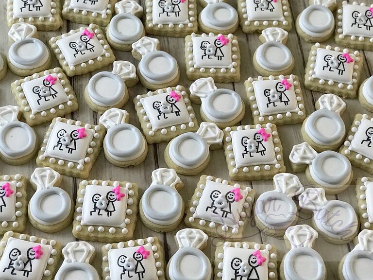 Square cookies frosted with stick couple design and wedding ring cookie design