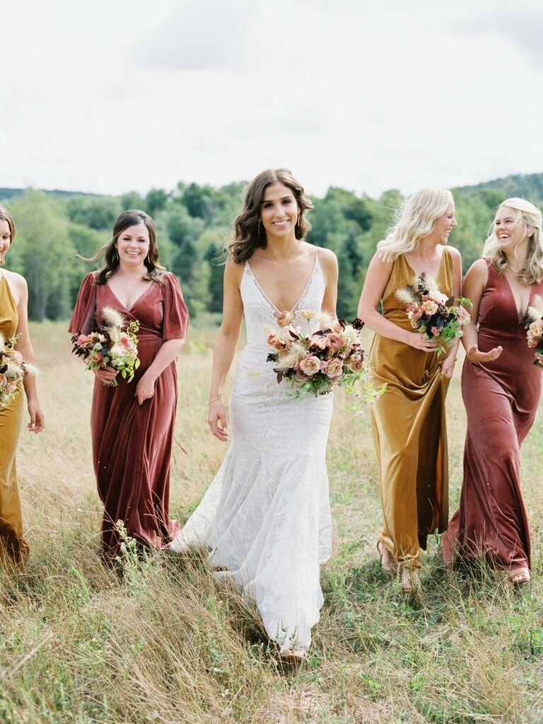 Bridesmaids wear velvet dresses in yellow and pink. 