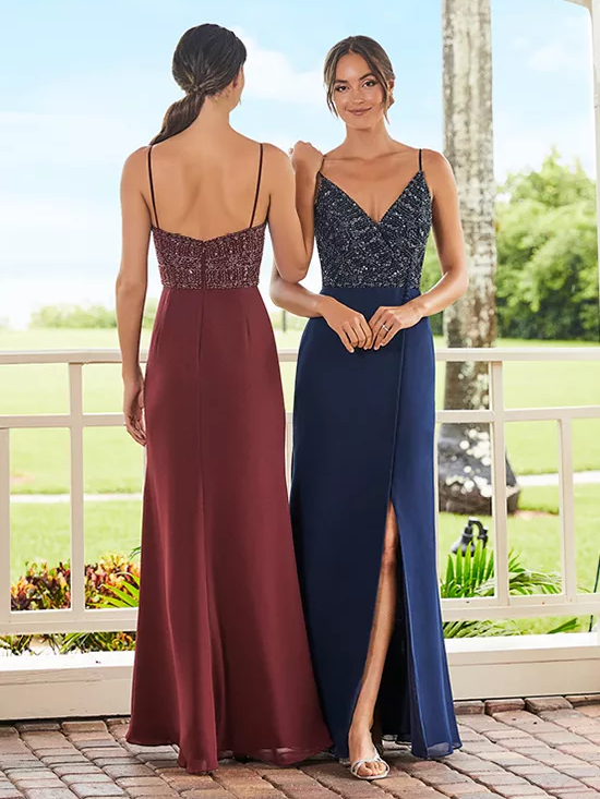 Two models wear different color options for this beaded spaghetti strap dress with a V-neckline and slit.