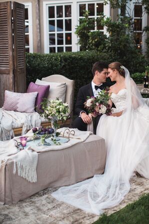 Bride and Groom on Lounge Couches Surrounded by Greenery and Romantic Details