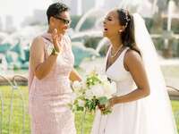 The bride and mother of the bride share a laugh together.