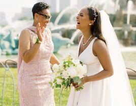 The bride and mother of the bride share a laugh together.