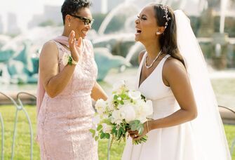The bride and mother of the bride share a laugh together.