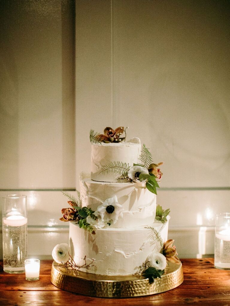 three tier buttercream wedding cake with white anemones and greenery