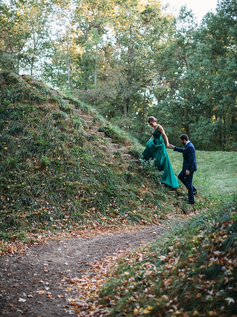 A couple climb up stone steps together for their engagement photoshoot