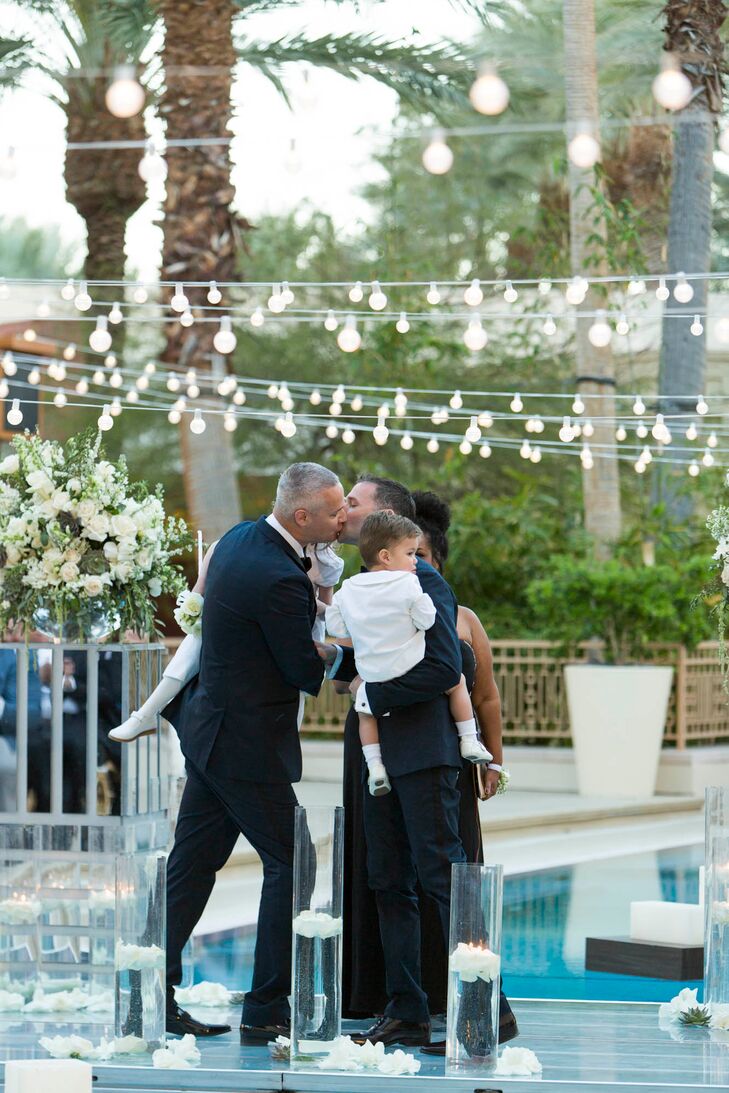Greg and Fletcher share their first kiss as a married couple while holding their two children. It was important for them to be included on the day, so they were present while the pair got ready and for most of the night.