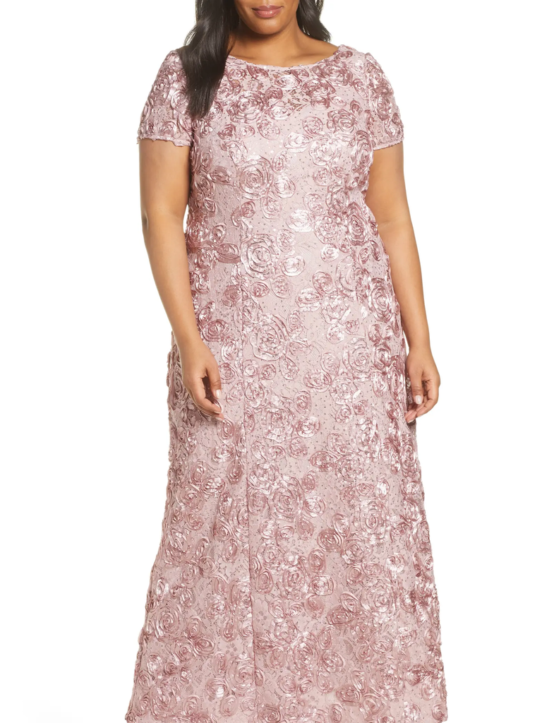 A model wears this pale pink gown with rose detailing. 