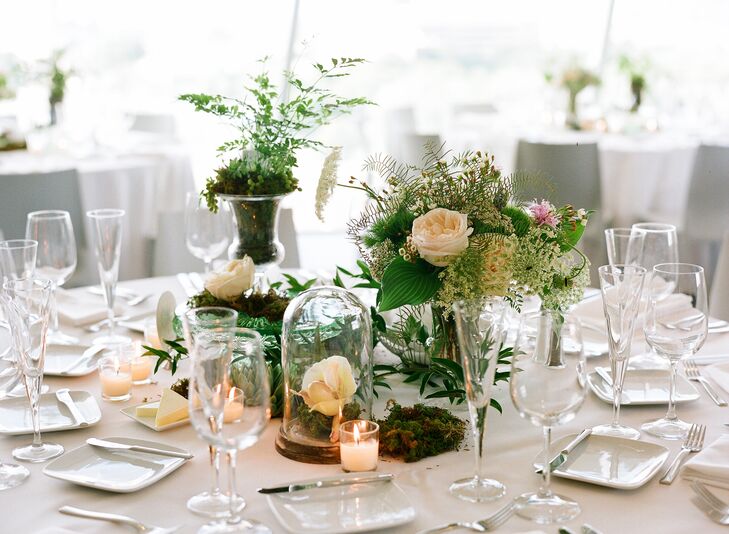 The reception tables at Walker Art Center were topped with a variety of high and low centerpieces and glass details. Ferns, green trick dianthus, roses, wildflowers and moss brought the outside in for a rustic aura.