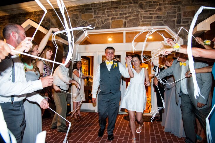 As Haley and Jeremiah exited the reception, guests stood on both sides of them waving white ribbons on sticks in celebration of their marriage. Haley changed into a more casual white cocktail dress with a V-neck for the reception.