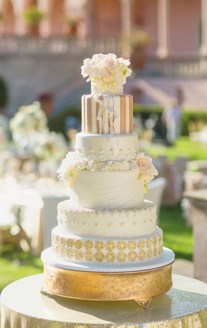 The couple served a grand six-tier wedding cake baked by Cakes by Ron. The berry chantilly cake was covered with blush and ivory sugar flowers, fondant, gold accents and intricate details on every tier.