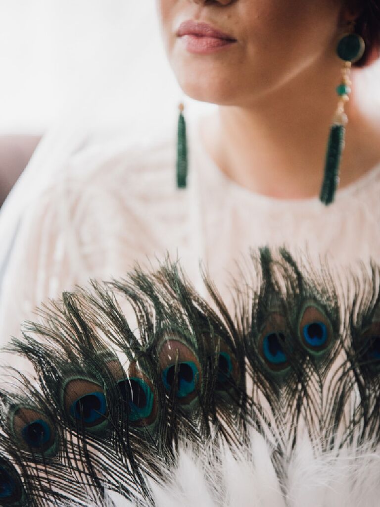 Vintage 1920's-inspired bride holding bouquet of peacock plumes