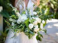 bride holding oversized wedding bouquet with spiral eucalyptus, white roses and other greenery