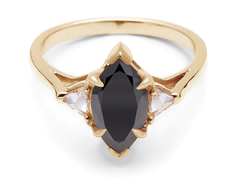 This modern engagement ring stuns with a marquise-cut black diamond, flanked by two trillion white diamonds.