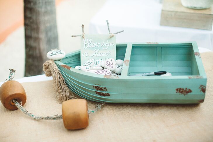 Instead of a traditional guest book, Whitney and Ryan had their friends and family members sign small white stones and place them in a small row boat.  rn