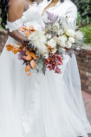 Two Brides in White Hold Fall-Themed Bouquets With Leaves and Neutral Flowers