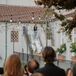 Bride Walking Down Steps With Floral Veil Under String Lights, Guests Looking On