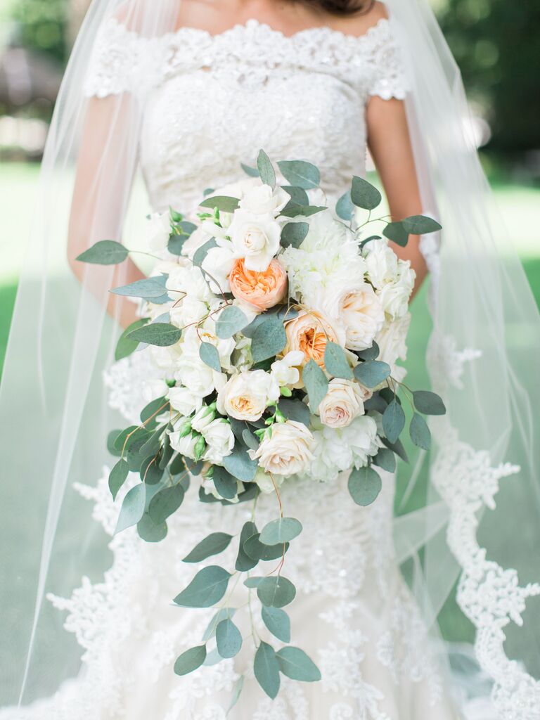 cascading summer wedding bouquet with white and peach garden roses, lisianthus and silver dollar eucalyptus