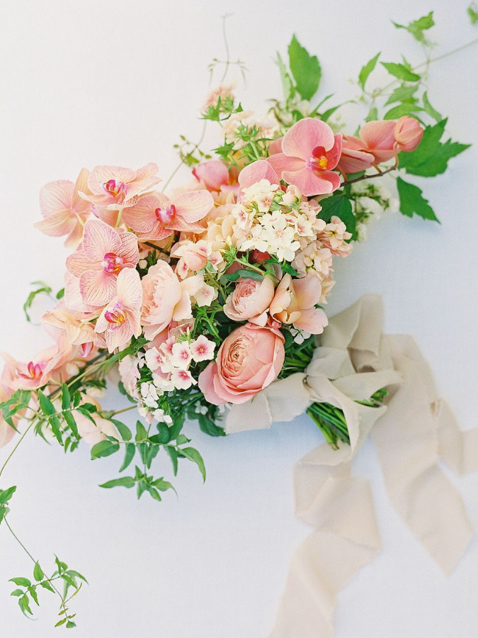 Peach-hued orchid bouquet with ribbon