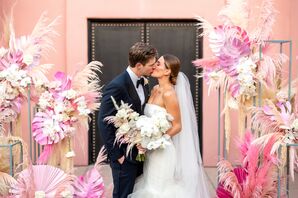 Couple Shares a Kiss at Their All-Pink Ceremony Altar With Pampas Grass and Painted Palm Leaves