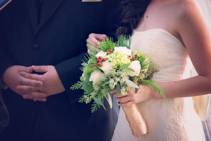 Camelia carried a holiday-inspired bouquet of pine, white roses and red hypericum berries with a gold wrap.