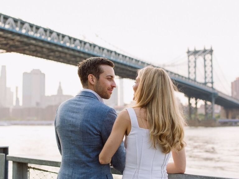 couple smiling during waterfront engagement shoot