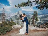 bride and groom embrace on river bank