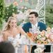 Romantic Couple at Sweetheart Table with Rose Flower Arrangement