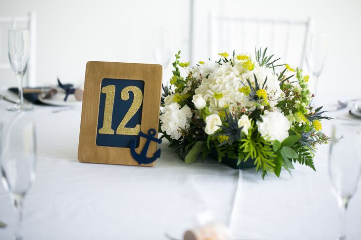 Since they love to boat on the Chesapeake Bay, it was fitting that a few anchors pop up in the decor. Each gold and navy table number was highlighted with these navy blue anchor decals at the corner.
